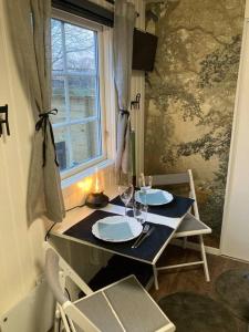 a dining table with two plates and a window at Mysig ministuga på privat läge landet in Blentarp +36 photos