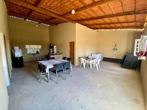 Großes Zimmer mit einem Tisch und Stühlen. in der Unterkunft Chácara Moreira in Tianguá