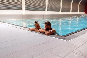 a man and a child in a swimming pool at Mirabeau Etoile in Zermatt