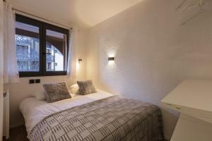 a bedroom with a bed and a window at Chamonix Sud - Jonquilles 209 - Happy Rentals in Chamonix-Mont-Blanc
