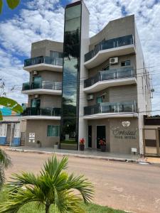 a building on a street with palm trees in front of it at Cristal Park Hotel in Cristalina