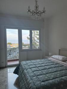 Nomadi Sedentari - Matera في ماتيرا: غرفة نوم بسرير ونوافذ وثريا