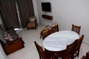 salon ze stołem, krzesłami i telewizorem w obiekcie Villa Encantos Casa de Campo w mieście Serra Negra