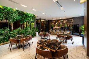 een restaurant met tafels, stoelen en planten bij Luxury Apartment with Saigon River View - Zenity in Ho Chi Minh-stad