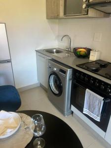 a kitchen with a stove and a washing machine at Premium Cozy Apartment (0% loadshedding) in Sandton