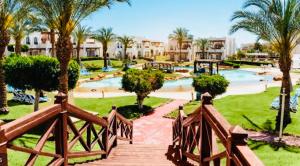 een resort met een zwembad en palmbomen bij Private Luxury Villas at Sharm Dreams Resort in Sharm El Sheikh