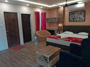 Pokój hotelowy z łóżkiem i krzesłem w obiekcie hp greenland resort w mieście Lataguri