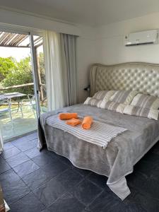 a bedroom with a bed with two orange towels on it at Hotel Butique Donatella Mare. in Punta del Este