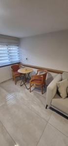 sala de estar con sofá y mesa en studio apartment, en Naẕerat ‘Illit
