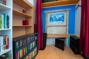 een kamer met boekenplanken en een raam met een bank bij The Book Nest in Ljubljana