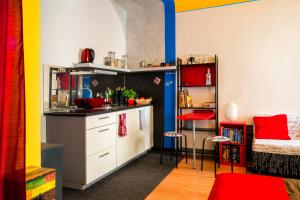 una cucina con armadi bianchi e pareti rosse e gialle di The Book Nest a Lubiana 1 altra foto