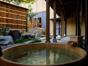 bañera de hidromasaje en medio de un edificio en 井波古香里庵 別邸 瑞雲, en Nanto