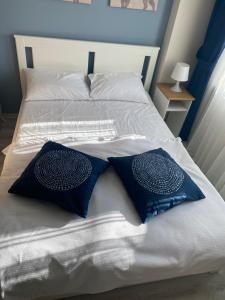 Una cama blanca con dos almohadas azules. en HOUSE KA HANIM, en Canakkale
