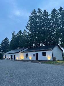 a white barn with lights on the side of it at The Barns of Brighton Near Prince Edward County in Brighton