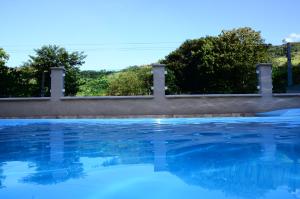 een zwembad met bomen op de achtergrond bij Villa Encantos Casa de Campo in Serra Negra