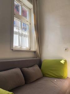 a couch with a green pillow sitting under a window at Haus Anastasia in Stolberg