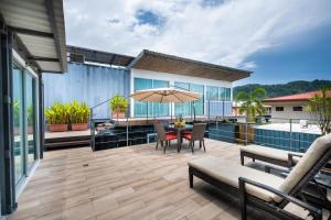 patio con tavolo, sedie e ombrellone di Hotel Bamboo a Jacó