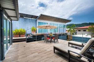 a patio with a table and chairs and an umbrella at Hotel Bamboo in Jacó