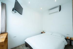 a bedroom with a bed and a tv on the wall at Hotel Bamboo in Jacó