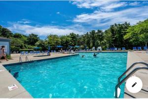 a large swimming pool with people in it at The Couples Nest Ocean Edge condo in Brewster