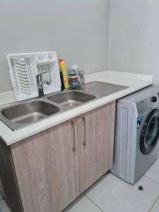 uma cozinha com um lavatório e uma máquina de lavar roupa em Fifi's home away from home em Midrand