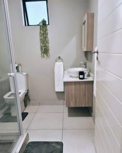 La salle de bains blanche est pourvue d'un lavabo et de toilettes. dans l'établissement Fifi's home away from home, à Midrand