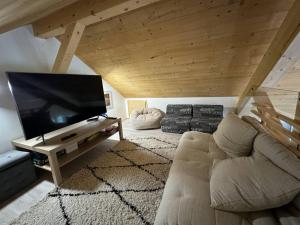 a living room with a couch and a flat screen tv at Maison Villard-de-Lans, 5 pièces, 8 personnes - FR-1-548-14 in Villard-de-Lans