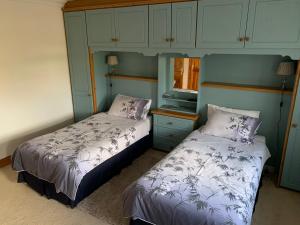 a bedroom with two beds and a window and cabinets at Rocklands Guesthouse in Castlebar