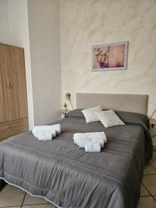 - une chambre avec un grand lit et des serviettes dans l'établissement Dimora Sole del Sud, à Ugento