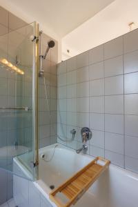 y baño con bañera y ducha. en Neve Tsedek 2BR Apartment By Nimizz, en Tel Aviv