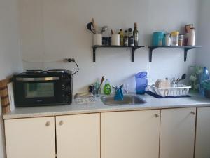 eine Küchentheke mit Mikrowelle und Spüle in der Unterkunft Bøelgaarden in Gørding