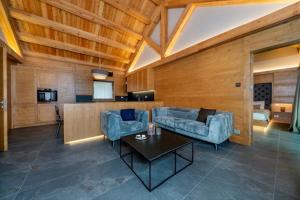 - un salon avec deux canapés bleus et une table dans l'établissement Kile Alpine Resort, à Valbruna