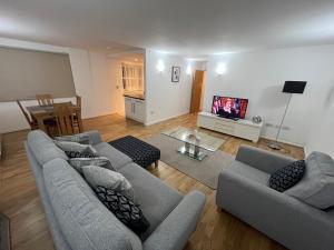 Sala de estar con 2 sofás y TV en Room with Private Bathroom Royal Victoria Excel O2 Arena London, en Londres