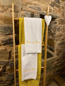 two towels on a towel rack in a stone wall at Casa do Tear in Sobreira Formosa