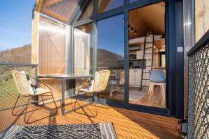 a patio with a table and chairs on a balcony at Premium Sustainable Cabins Mecsek Reindeer in Hosszúhétény