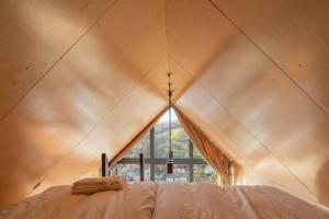 a bedroom with a large window in a tent at Premium Sustainable Cabins Mecsek Reindeer in Hosszúhétény