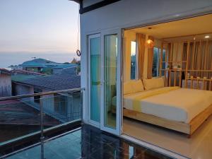 a bed on the balcony of a house at Habor House by Koh Larn Riviera in Ko Larn