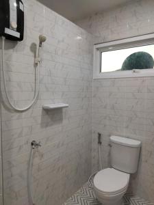 a white bathroom with a toilet and a shower at Habor House by Koh Larn Riviera in Ko Larn