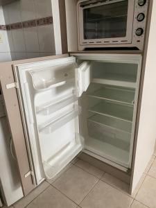 Il comprend une cuisine équipée d'un réfrigérateur ouvert et d'un four micro-ondes. dans l'établissement APPART - T3 - 6 PERSONNES – GOLF CAP D’AGDE, au Cap d'Agde