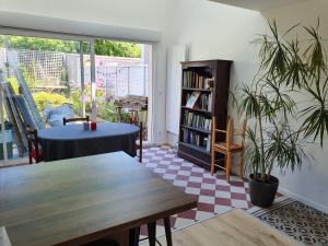 a living room with a table and a book shelf at Chambre privée chez l'habitant en colocation dans agréable maison avec jardin - A private room in a shared house with garden in Bordeaux