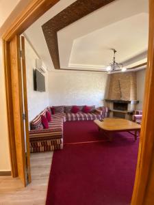 ein Wohnzimmer mit einem Sofa und einem Tisch in der Unterkunft Villa famille Bilal Agafay in Marrakesch