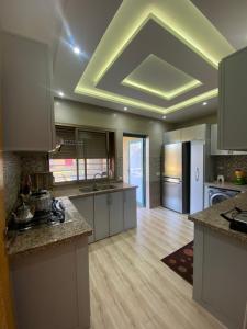 馬拉喀什的住宿－Villa famille Bilal Agafay，一间铺有木地板的大厨房,拥有格子天花板
