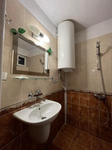 a bathroom with a sink and a mirror at Guest House Rosenovi in Lyaskovo