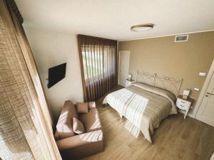- une chambre avec un lit et un canapé dans l'établissement Villacolle Visso, à Visso