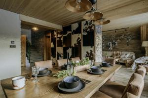 a dining room with a wooden table and chairs at Luxury Chalet Kajmer in Jurgów