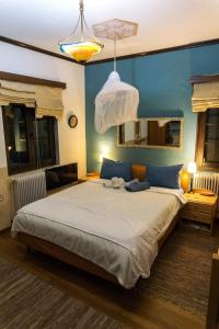 a bedroom with a large bed and a blue wall at Villa Tethys Mountain Resort in Zákas