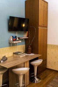 a desk with two stools and a television on a wall at Villa Tethys Mountain Resort in Zákas