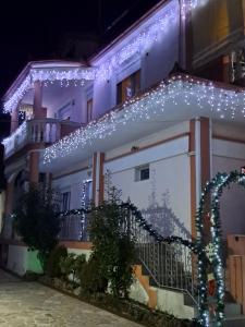 ein Haus mit Weihnachtslichtern an der Seite in der Unterkunft Erodios Guesthouse in Kato Loutraki