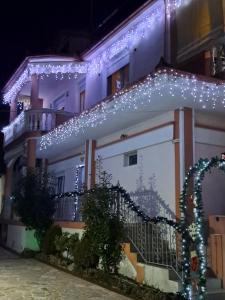 a house with christmas lights on the side of it at Erodios Guesthouse in Kato Loutraki
