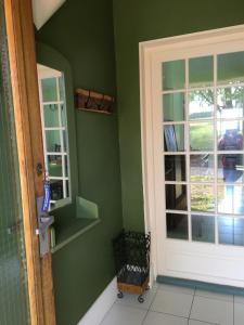 a green room with a door and a window at Maison de famille Jo et Juliette in Suin